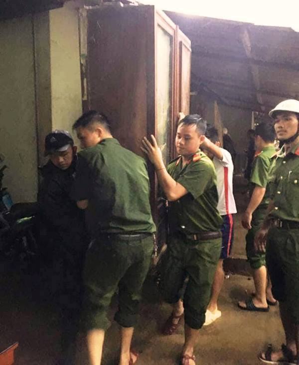 Các chiến sĩ, cán bộ công an huyện Kỳ Sơn dầm mưa để vận chuyển đồ đạc cho dân.