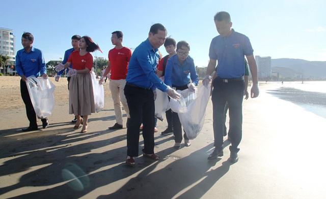 Phó Chủ tịch UBND tỉnh Bình Định Nguyễn Phi Long (trái) tham gia nhặt rác làm sạch bãi biển Quy Nhơn.