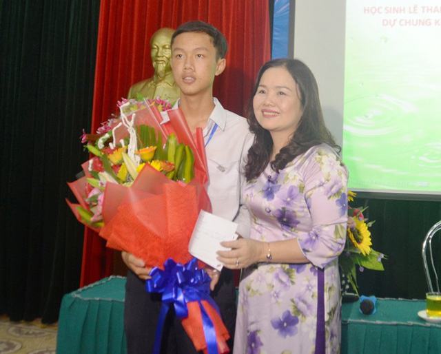 Giám đốc Sở GD&ĐT Lê Thị Hương tặng hoa chúc mừng em Tân Nhật (Ảnh: Sở GD-ĐT)